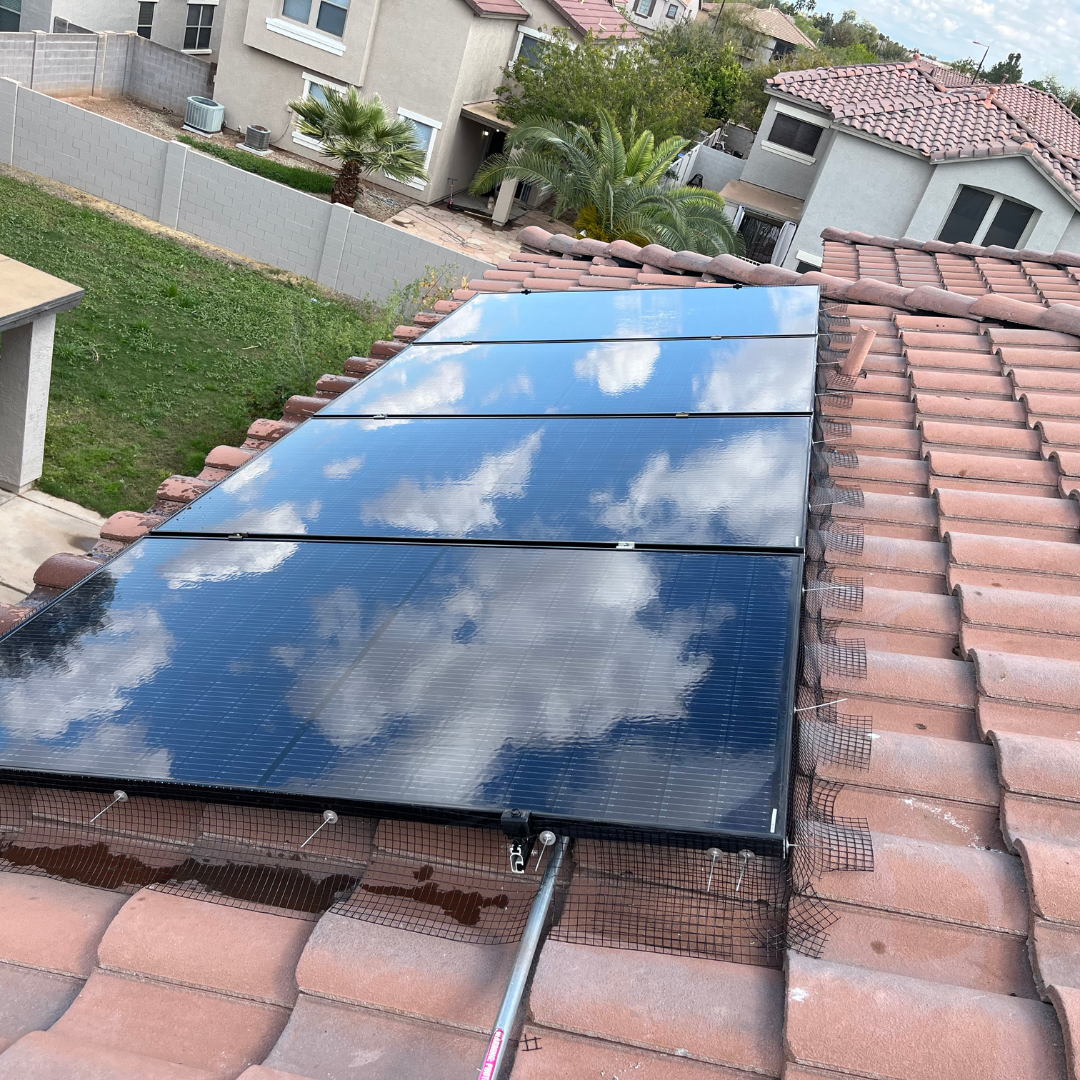 A row of solar panels are sitting on top of a tiled roof.
