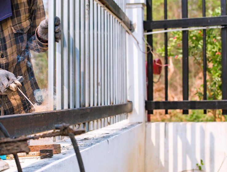Welders Fixing the Fence Using Iron Oxide — Gates & Fencing in Coffs Harbour, NSW