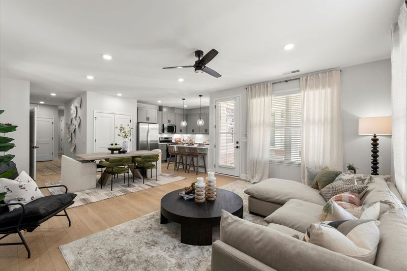 A fitness studio features a rack with yellow, green, and blue exercise balls, wood floors, and floor-to-ceiling windows.
