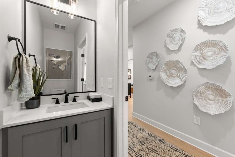 A modern bathroom with a gray vanity and decorative wall art at Hayloft Big Creek, offer 55+ homes for rent in Alpharetta, GA.