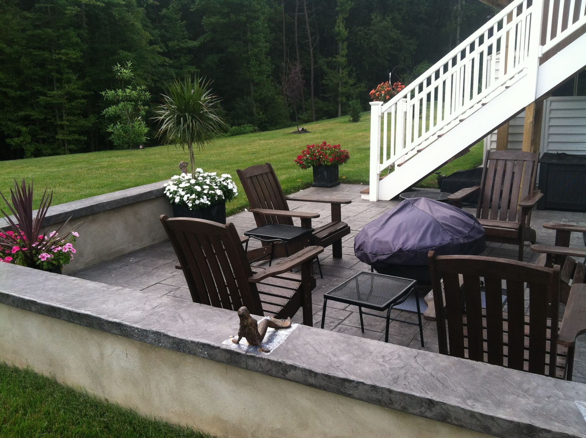 a  stamped concrete  patio with wooden chairs and a purple umbrella