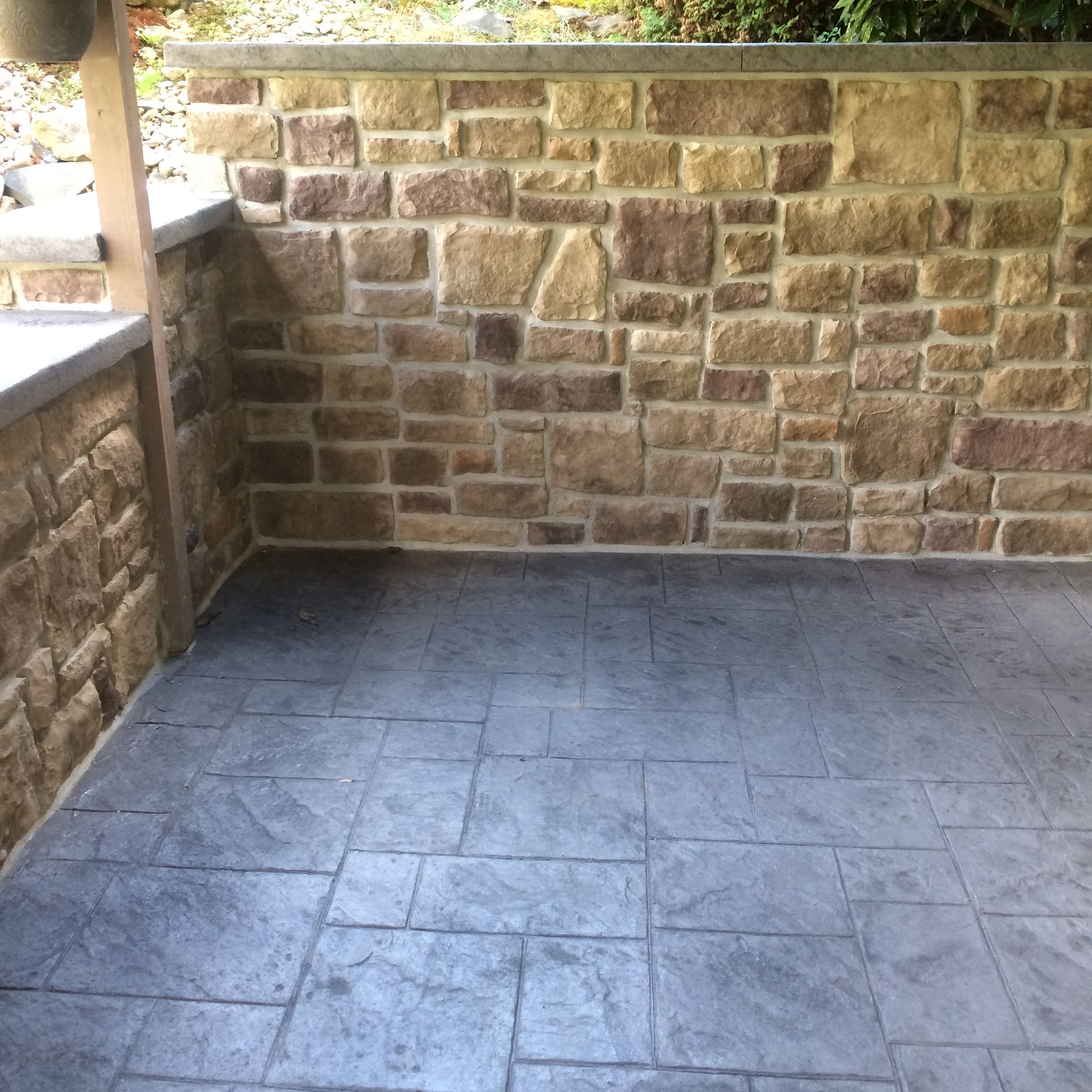 a brick wall with a  stamped concrete  floor in front of it