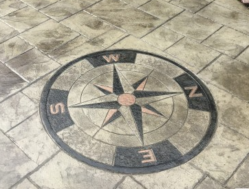 a  stamped concrete compass on a slate look patio