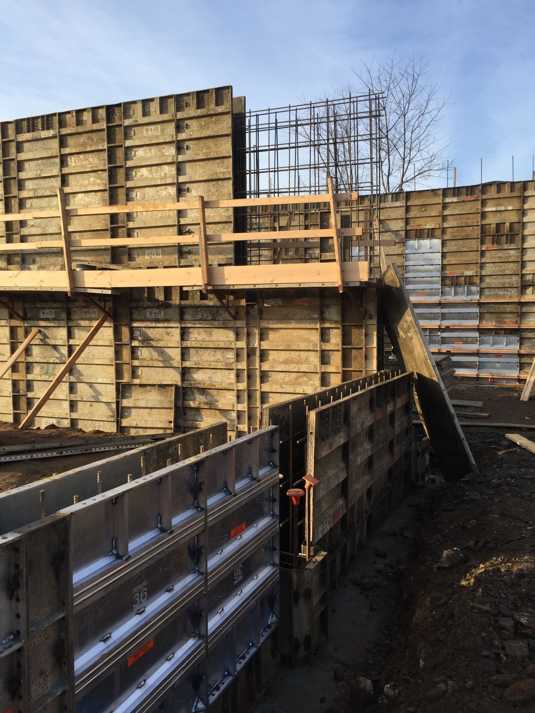 a large concrete wall is being built on a construction site .
