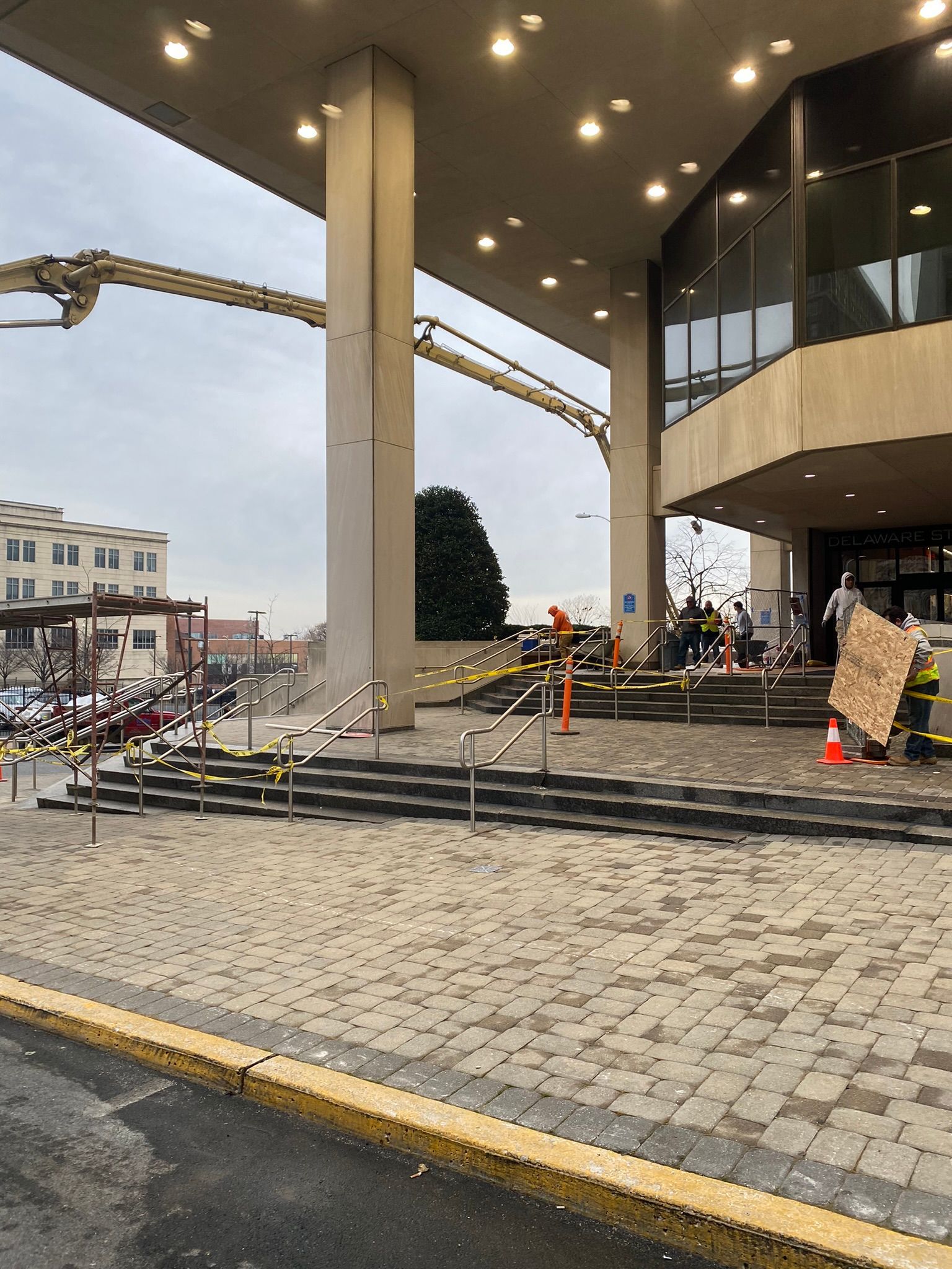 a concrete deck being poured at a large building with stairs