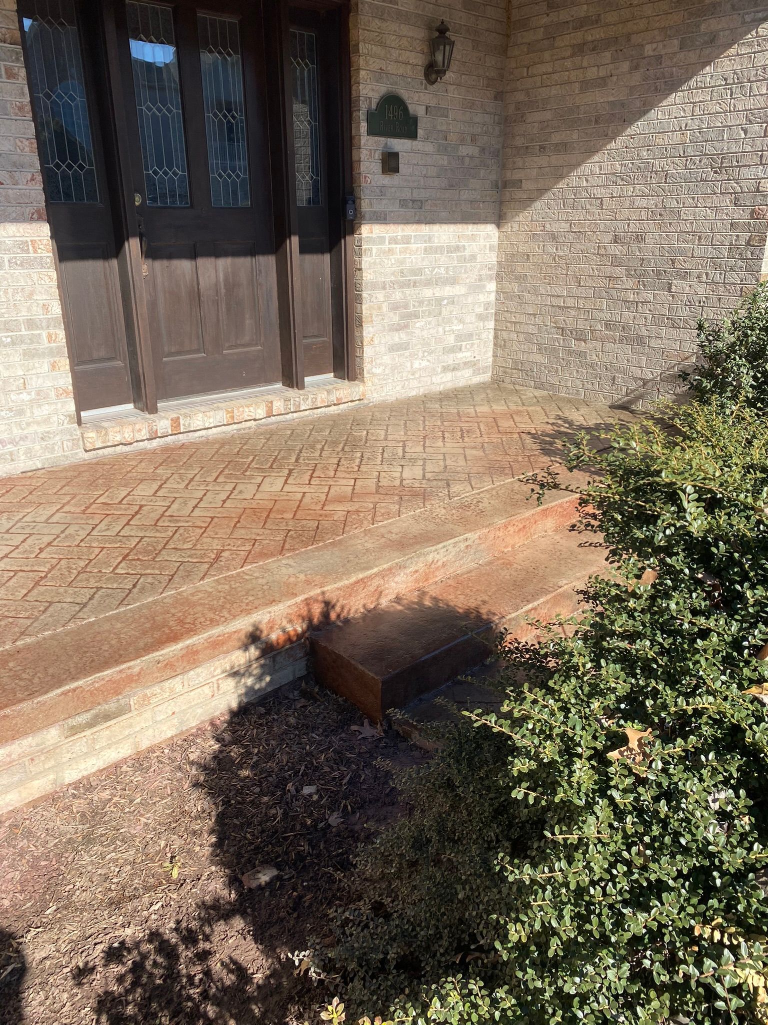A  stamped concrete front porch that looks like brick.