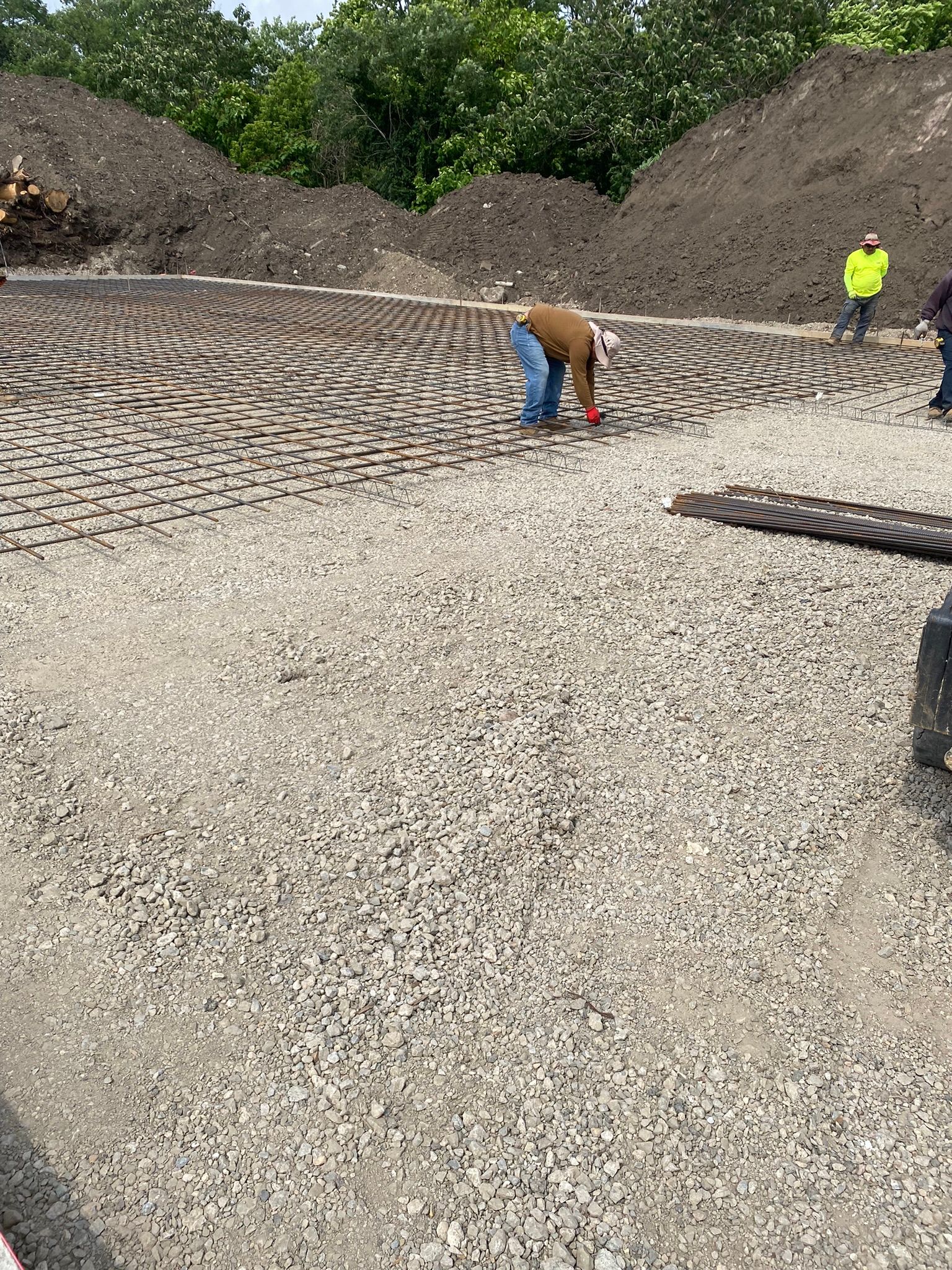 a group of construction workers are working on a  rebar grid for a concrete slab