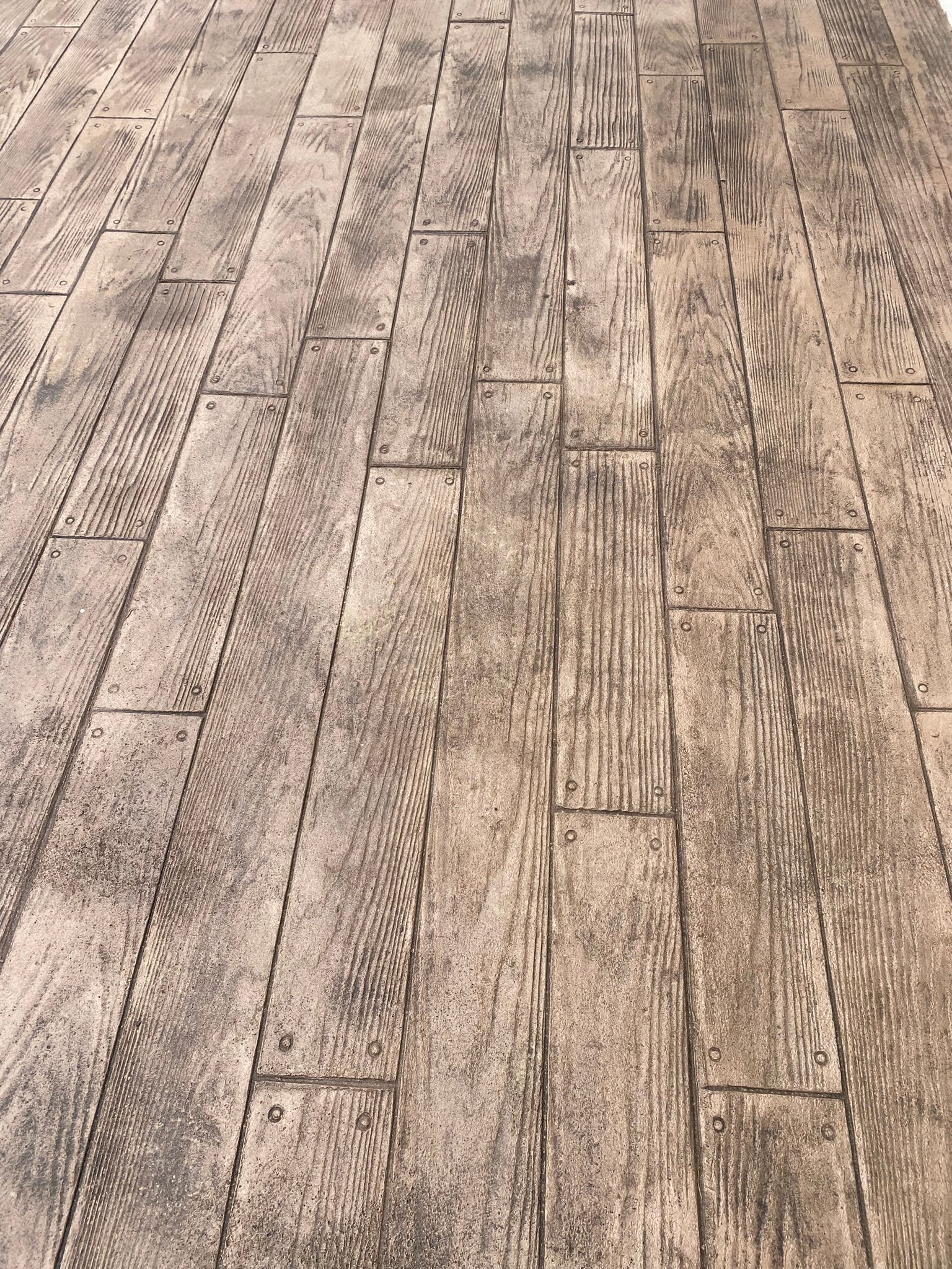a close up of a  stamped concrete floor that looks like wood .