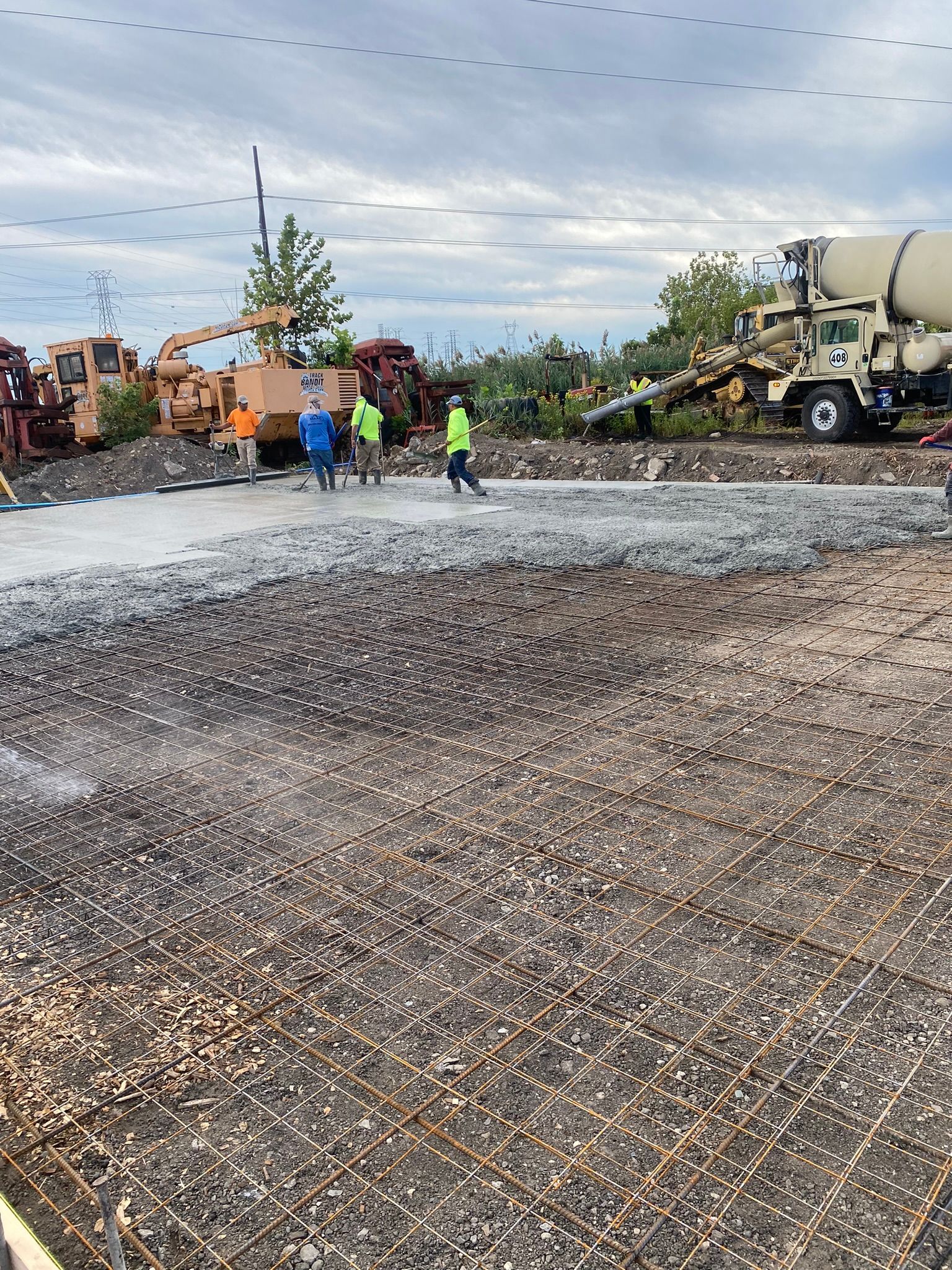 a concrete mixer truck is pouring concrete into a gravel lot .