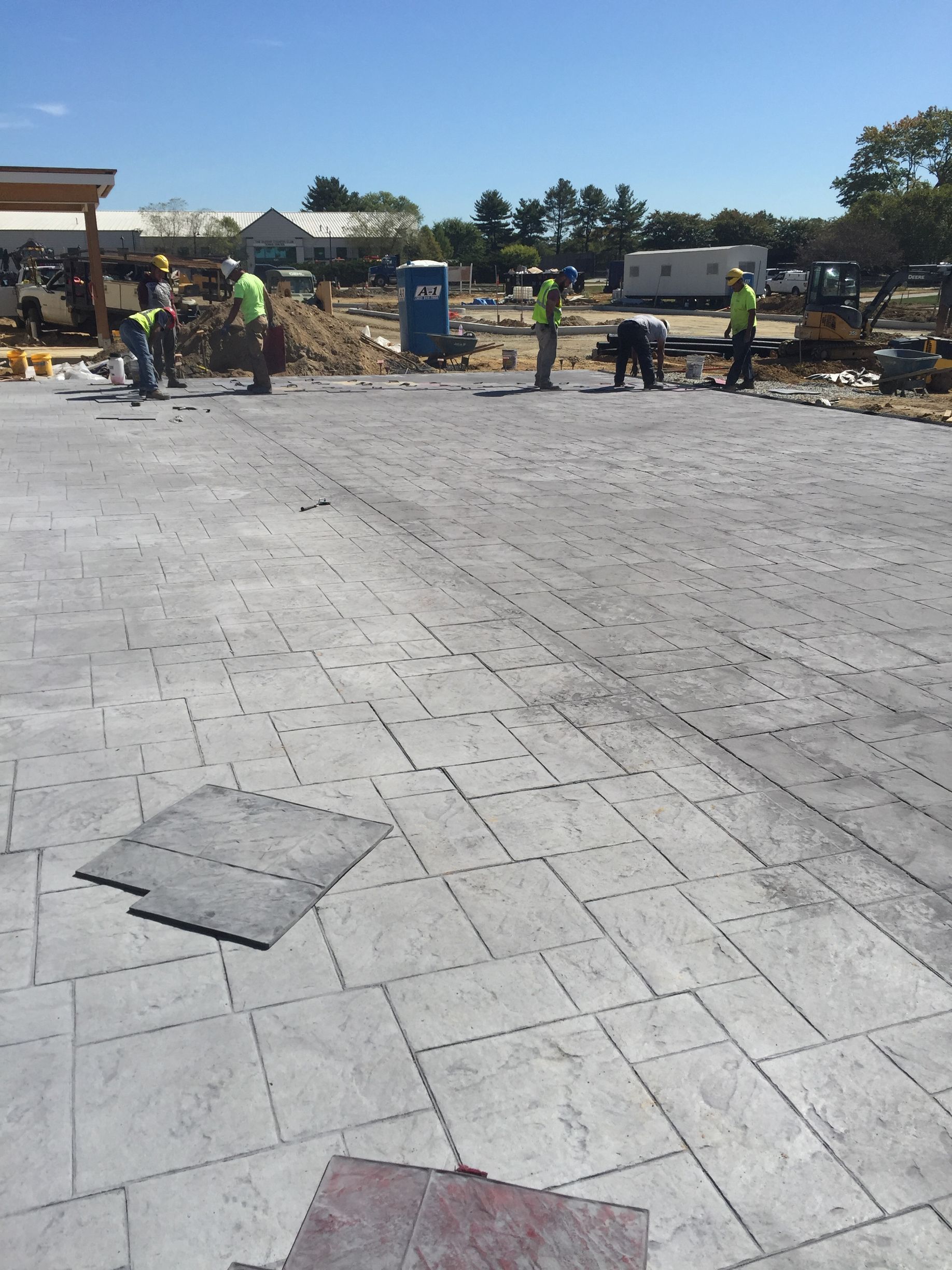 a group of construction workers are working on  stamped concrete  floor