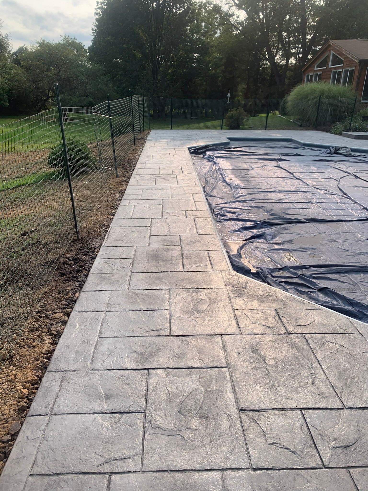 a  stamped concrete slate-like swimming pool deck.