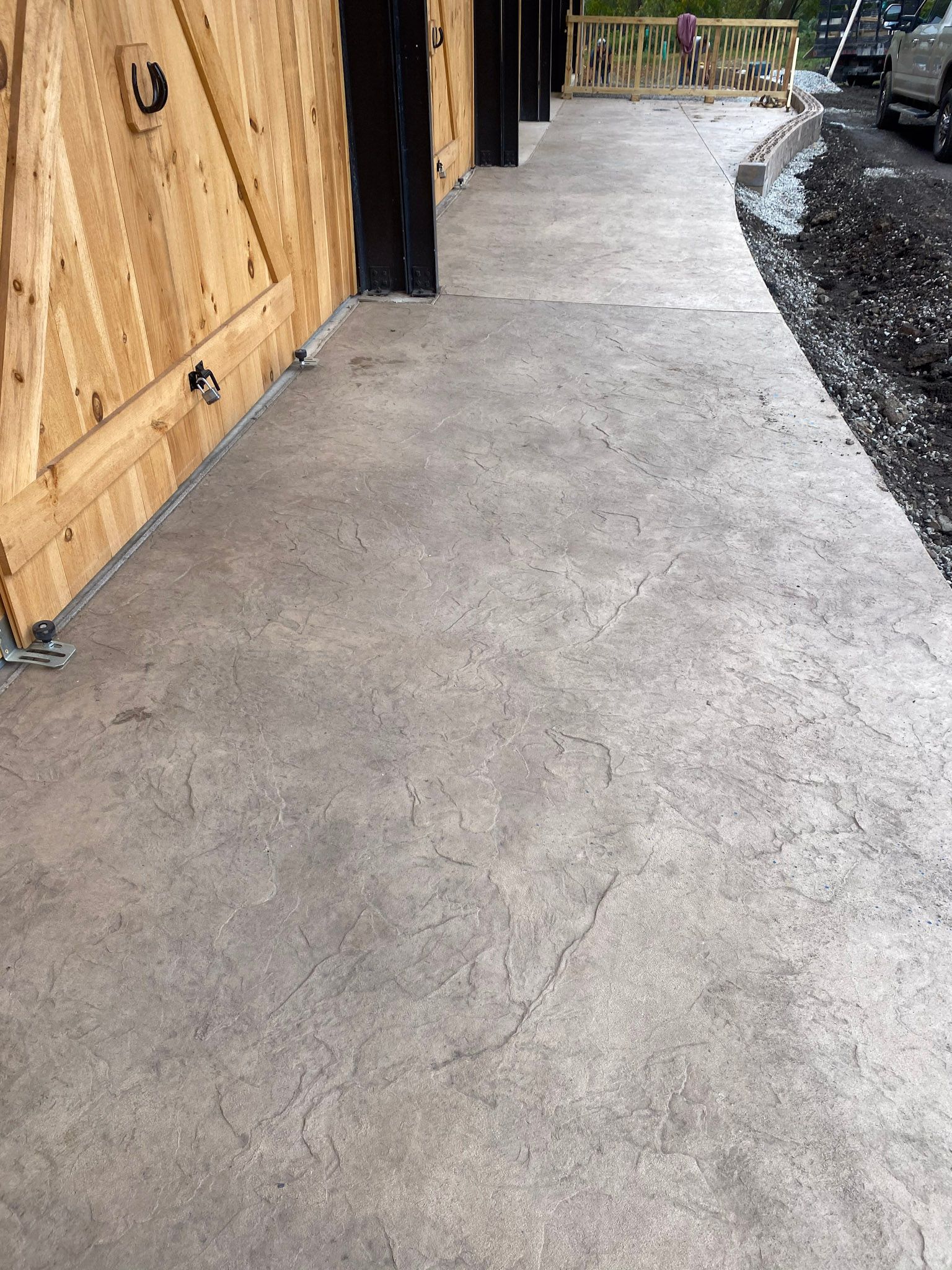 a  stamped concrete walkway leading to a wooden garage door .