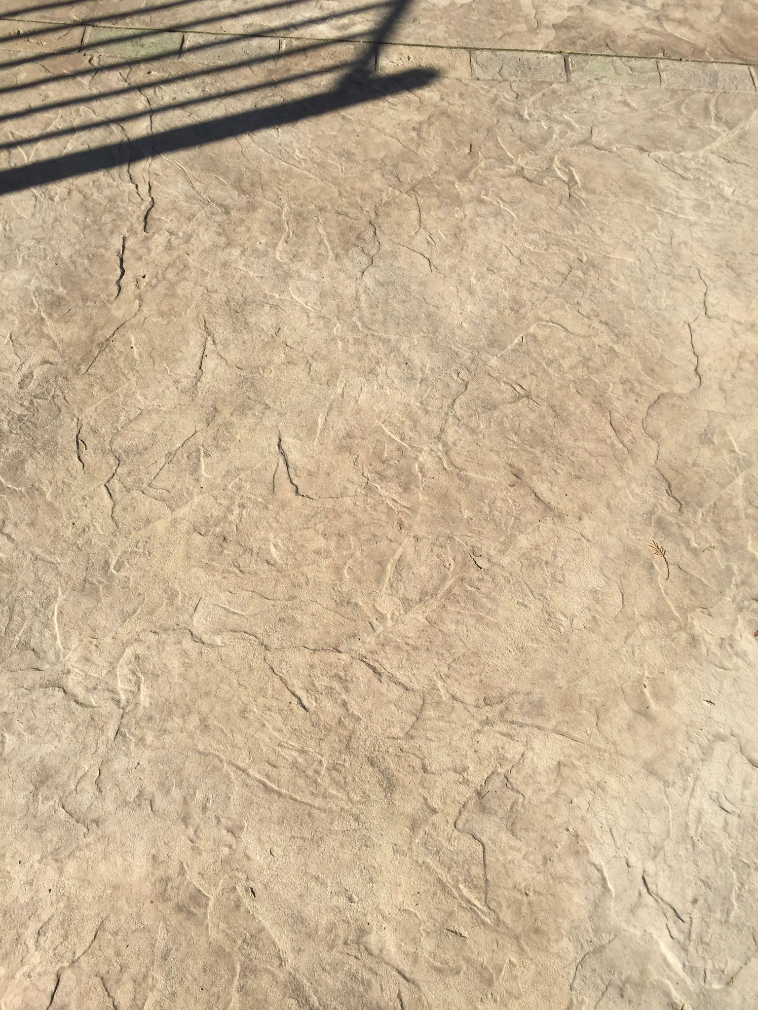 a close up of a  stamped concrete 
 concrete deck with a shadow on it .