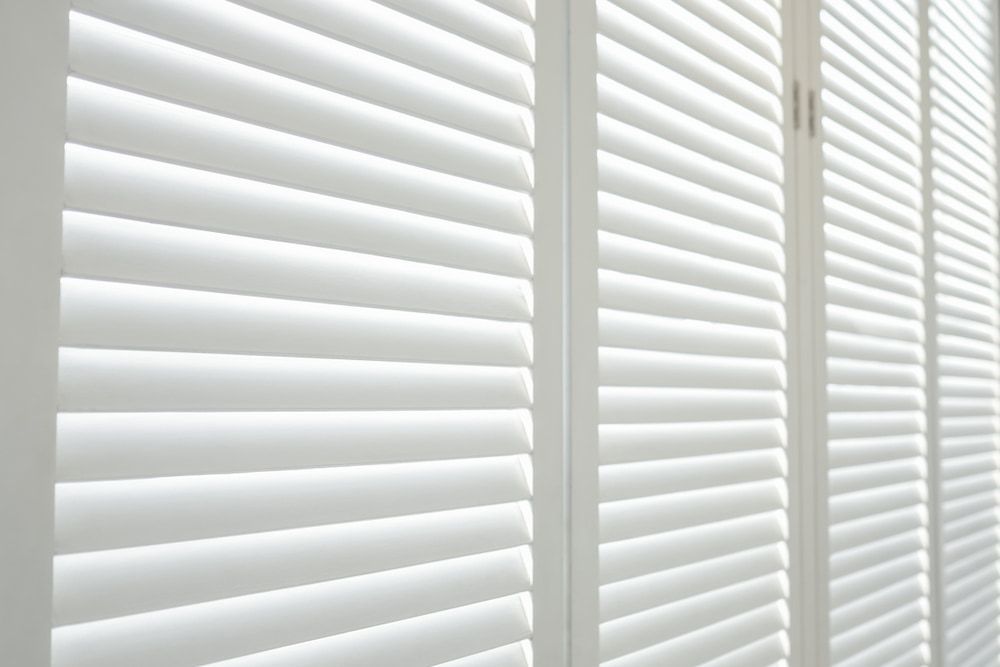 A Sliding Glass Door with Shutters on It — Mi-ekka Designs in Cannonvale, QLD