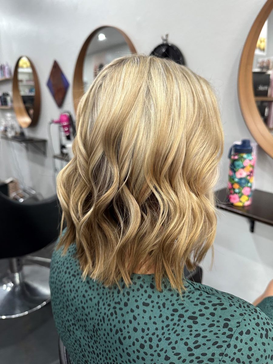 A Woman With Blonde Hair Is Sitting In A Chair In A Salon — Cut Loose Haircare Outlet In Lismore, NSW