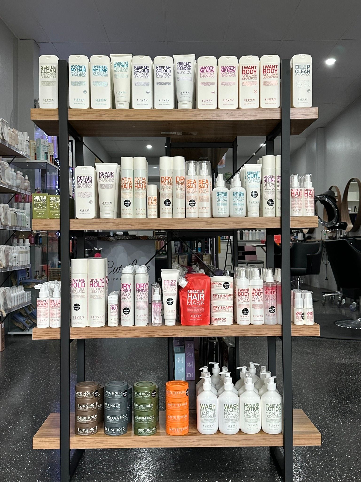 A Woman Is Getting Her Hair Curled By A Hairdresser — Cut Loose Haircare Outlet in Lismore, NSW