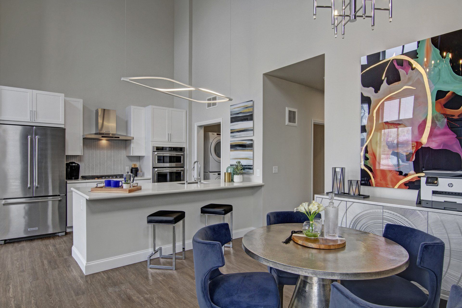 A kitchen with a table and chairs and a painting on the wall at Daymark Uptown Apartments.