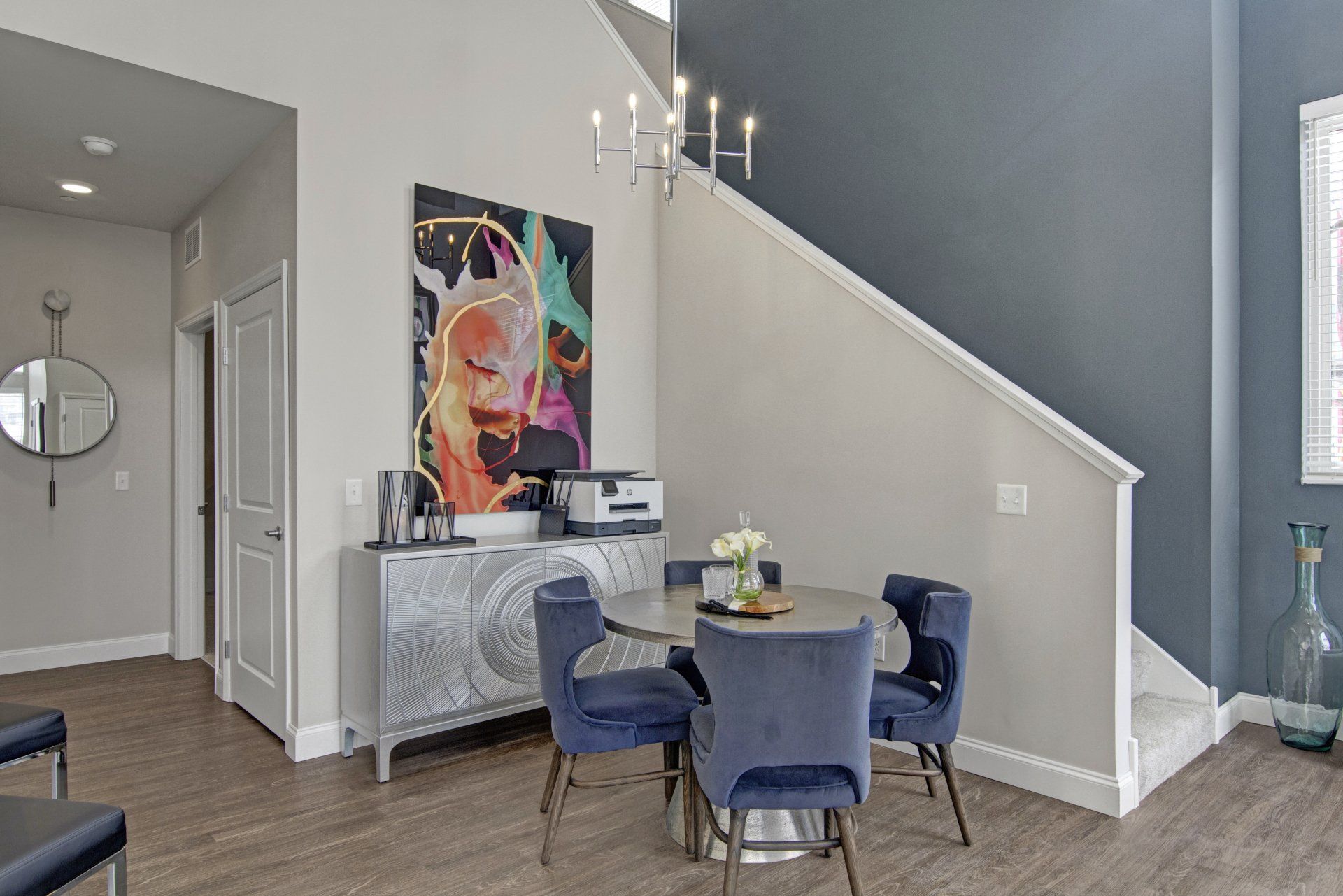 A dining room with a table and chairs and stairs at Daymark Uptown Apartments.