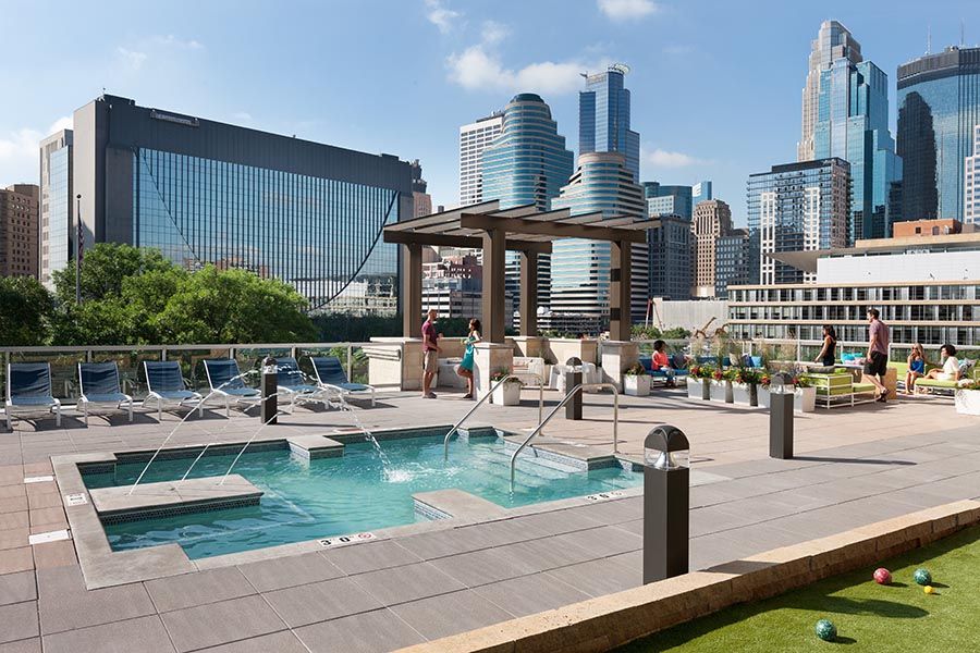 A large swimming pool with a gazebo in the background and a city skyline in the background.