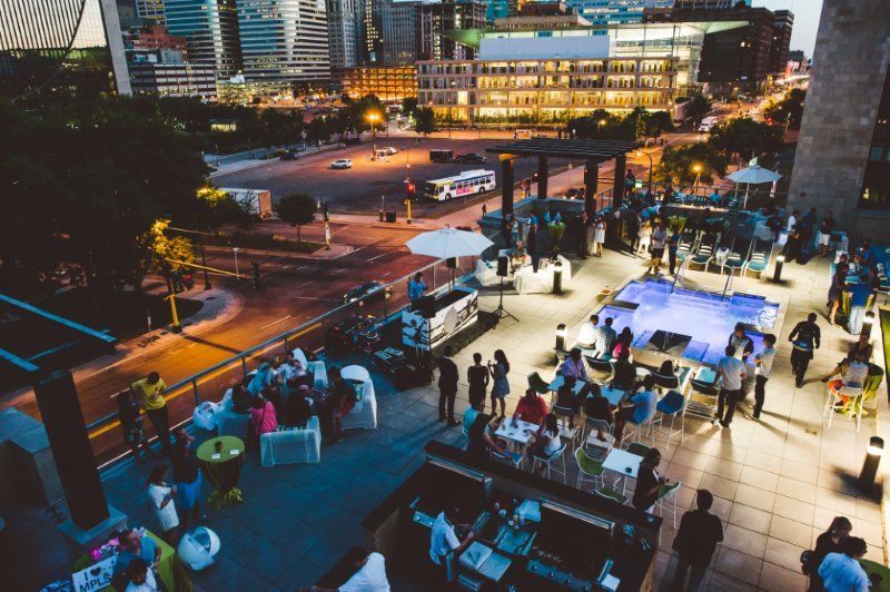 A group of people are standing around a pool in a city at night.