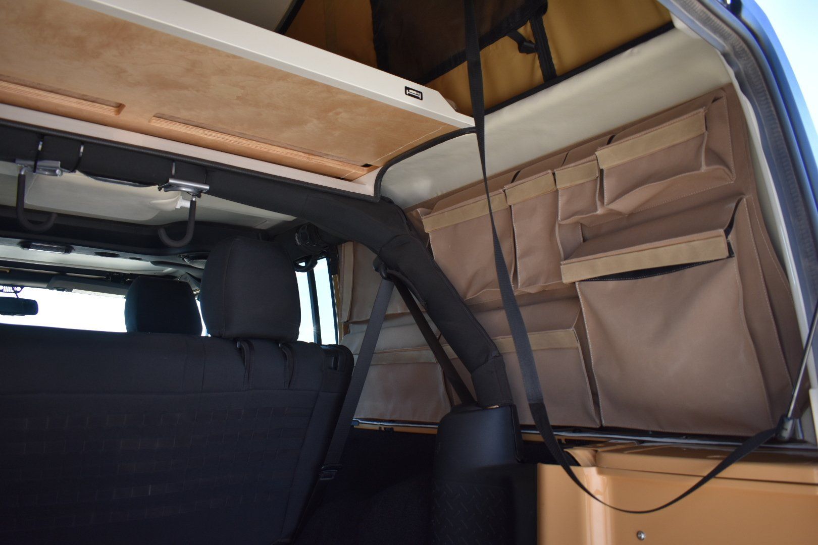 A jeep JXL with a rooftop tent attached to it.