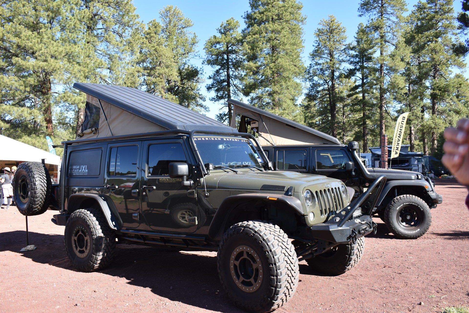 An American Safari JXL with a pop up roof is parked next to another JXL.