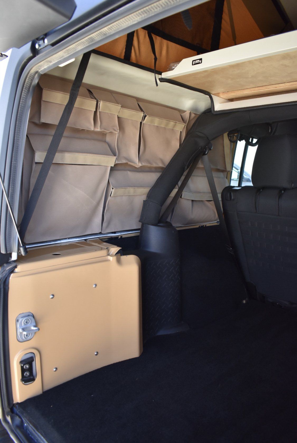 The back of a JXL with a tent on top of it