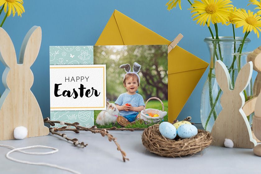 A happy easter card with a picture of a little girl blowing a dandelion.