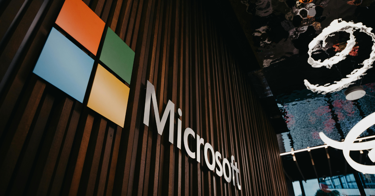 Microsoft logo on a wooden wall inside a corporate building.