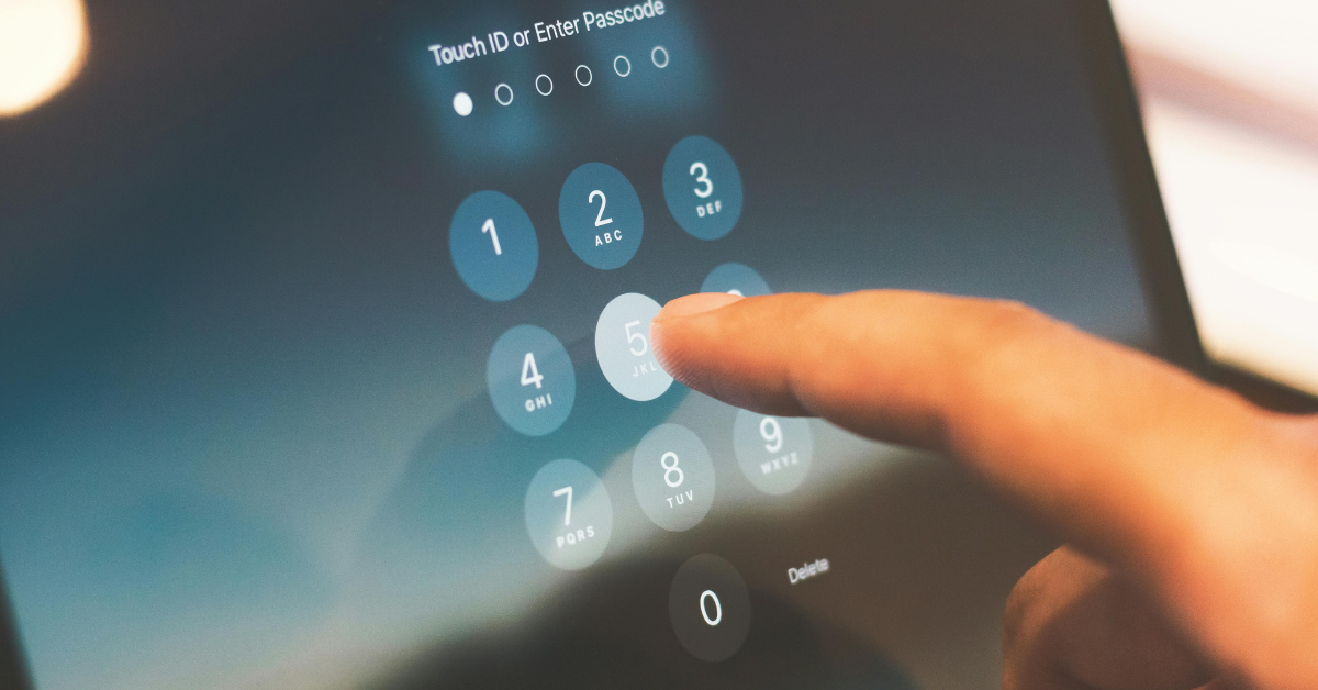 Hand entering passcode on a digital keypad screen, symbolizing modern security access.