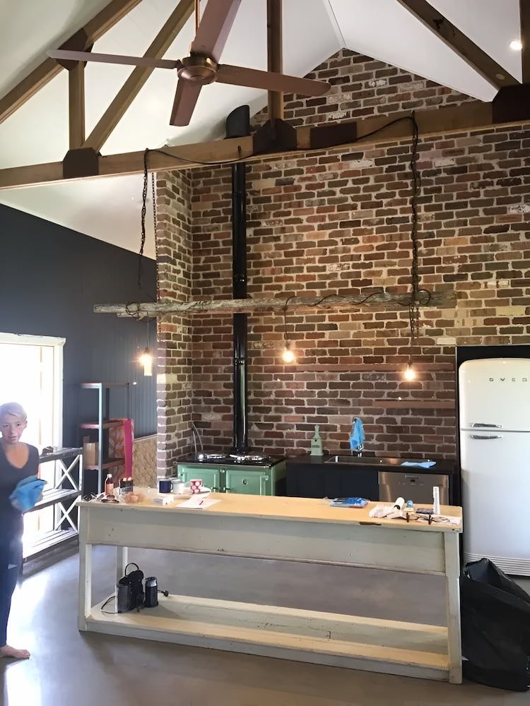 A Kitchen With A Brick Wall And A White Refrigerator — In-Line Electrical Southern Highlands in Bowral, NSW