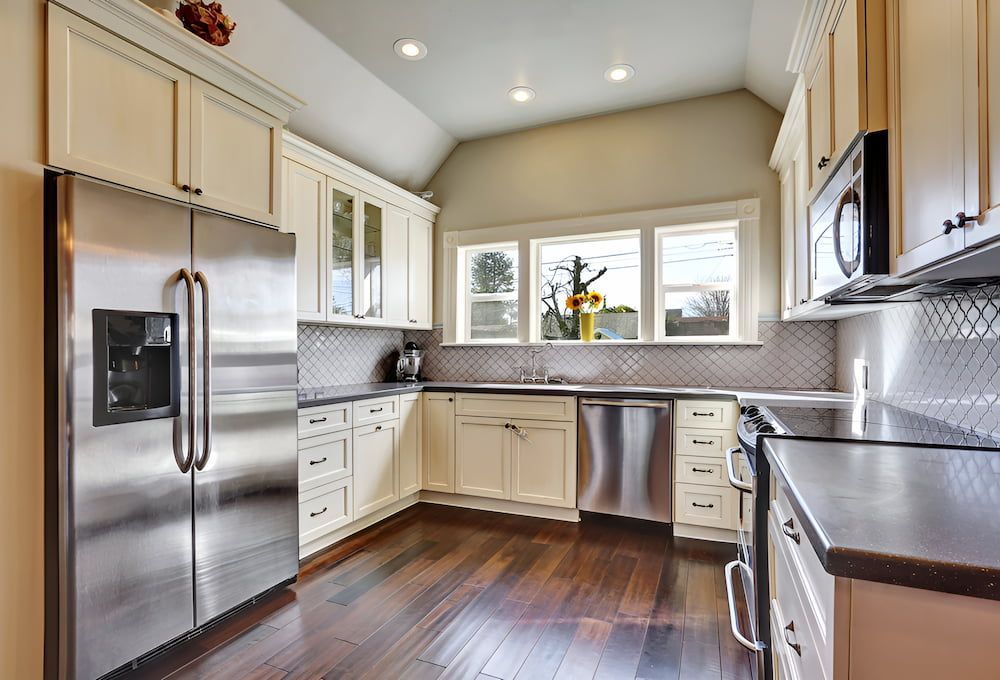 A Kitchen With Stainless Steel Appliances And White Cabinets — In-Line Electrical Southern Highlands in Mittagong, NSW