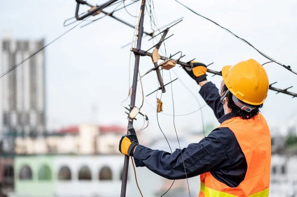 An Electrician Is Working On A Power Line — In-Line Electrical Southern Highlands in Mittagong, NSW
