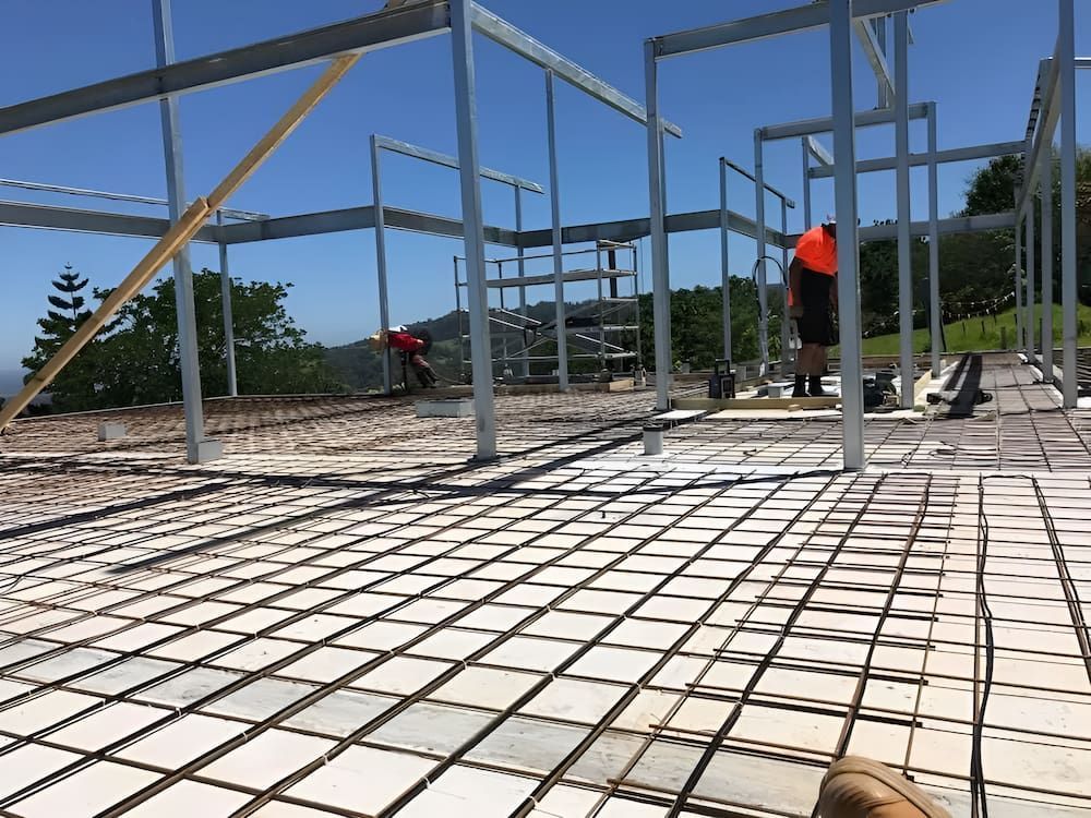A Person Standing On A Concrete Floor At A Construction Site — In-Line Electrical Southern Highlands in Carrick, NSW