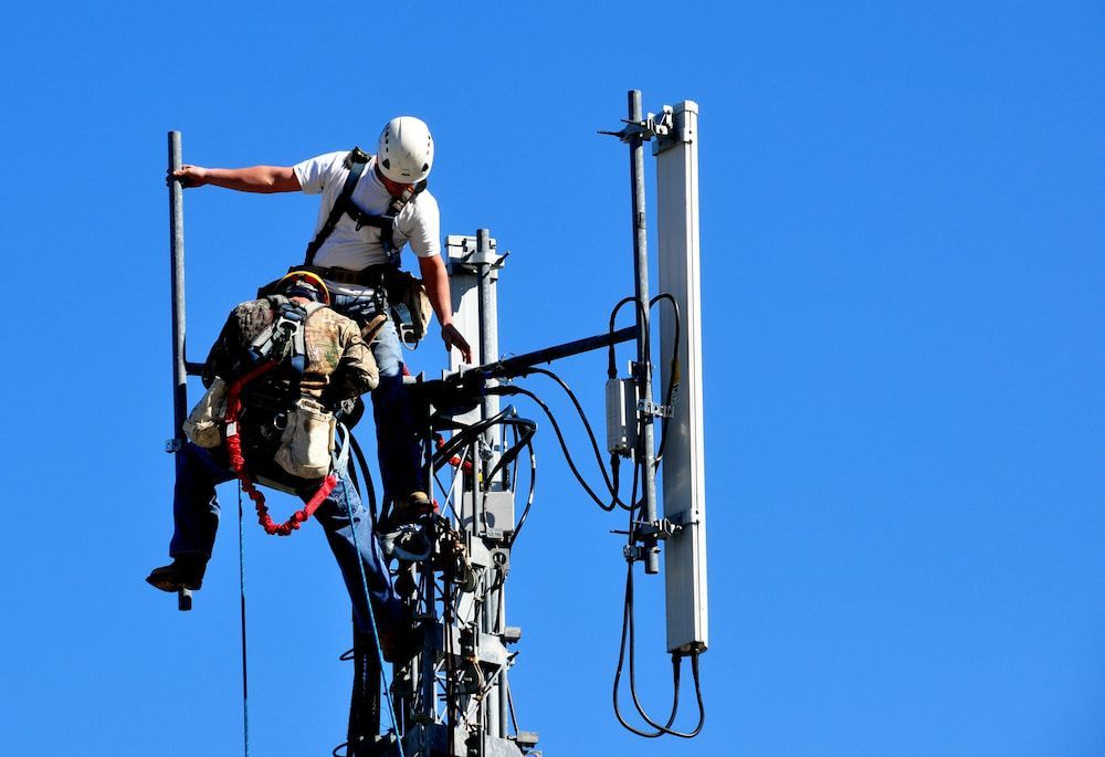 Two Men Are Working On A Cell Phone Tower — In-Line Electrical Southern Highlands in Goulburn, NSW