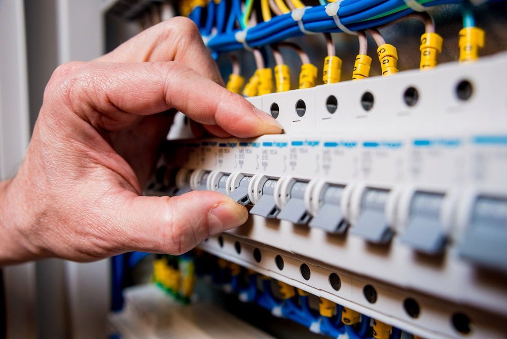 A Person's Hand Holding A Circuit Breaker — In-Line Electrical Southern Highlands in Marulan, NSW