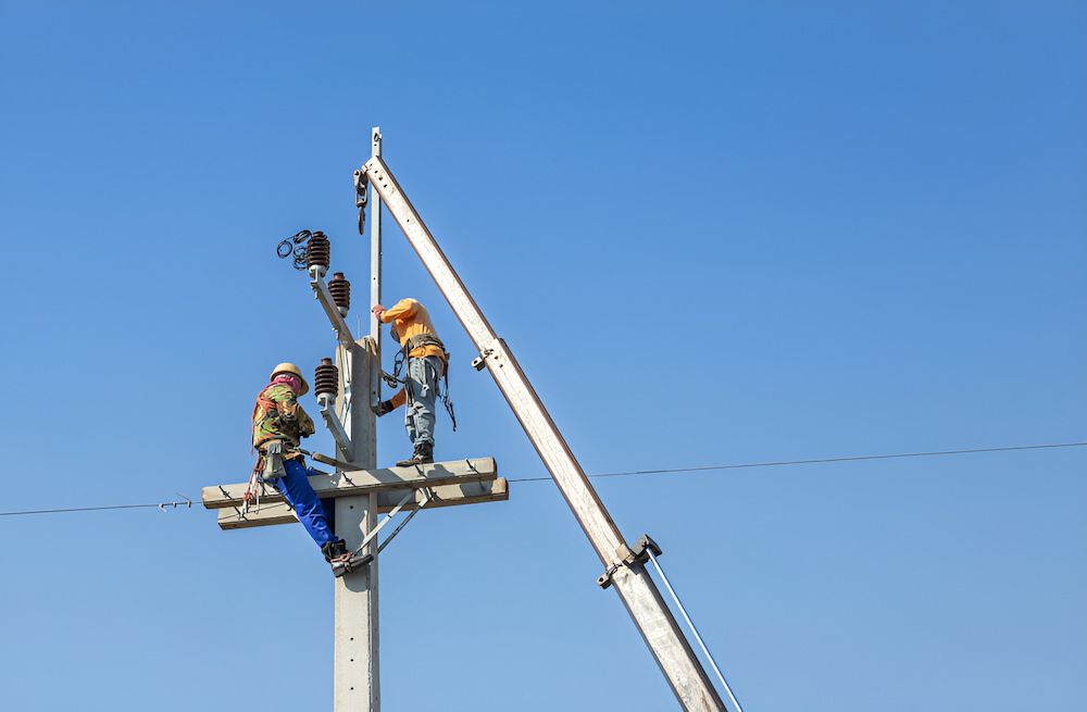 A Group Of Men Are Working On A Power Pole — In-Line Electrical Southern Highlands in Bowral, NSW