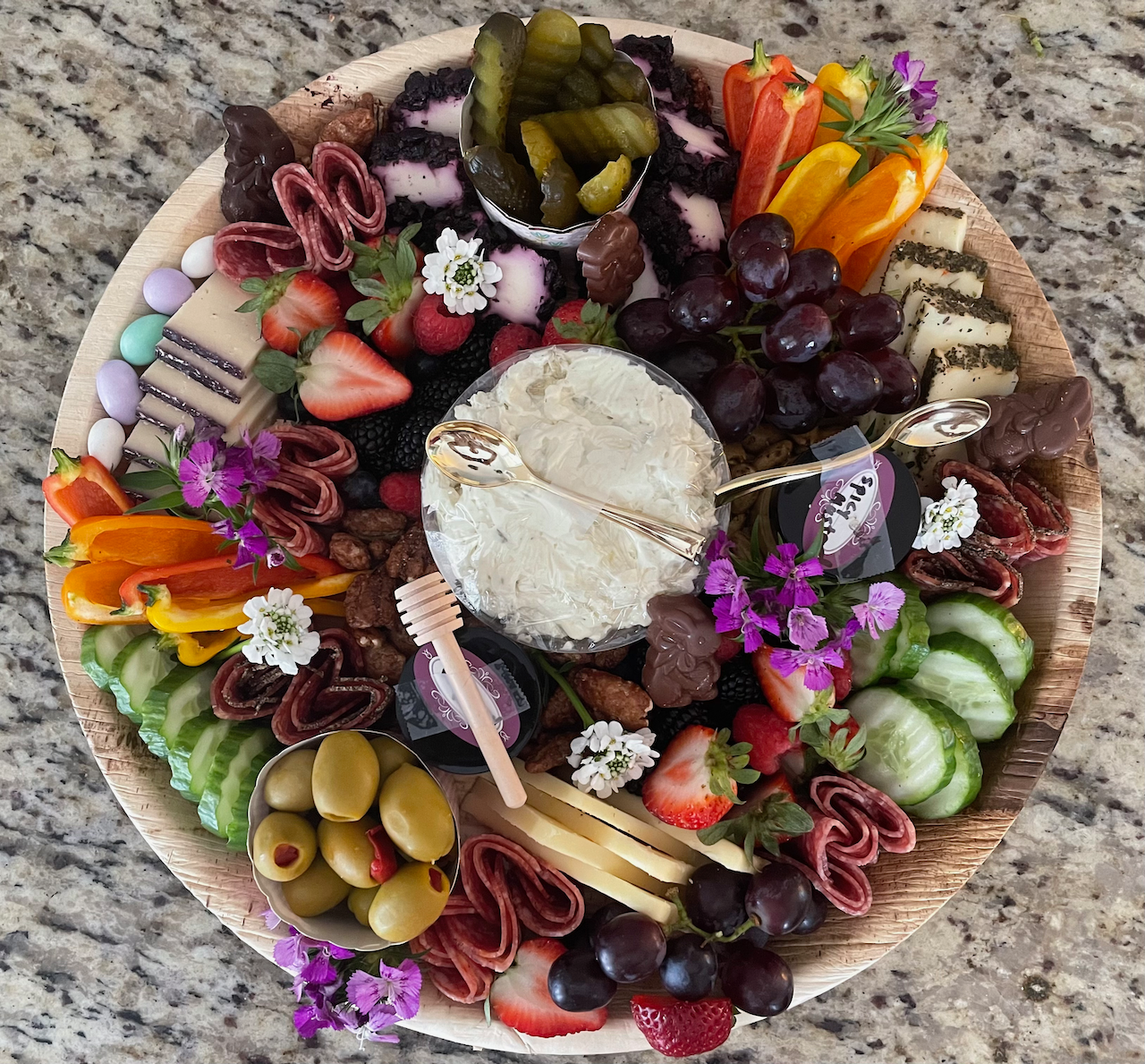 A wooden plate filled with fruits and vegetables on a table.