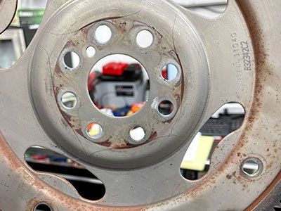 Flywheel with cracks and rust, seen up close. | Frontline Auto Repair