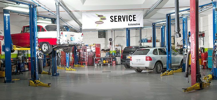 A car repair shop interior. Cars on lifts, tools, and a 