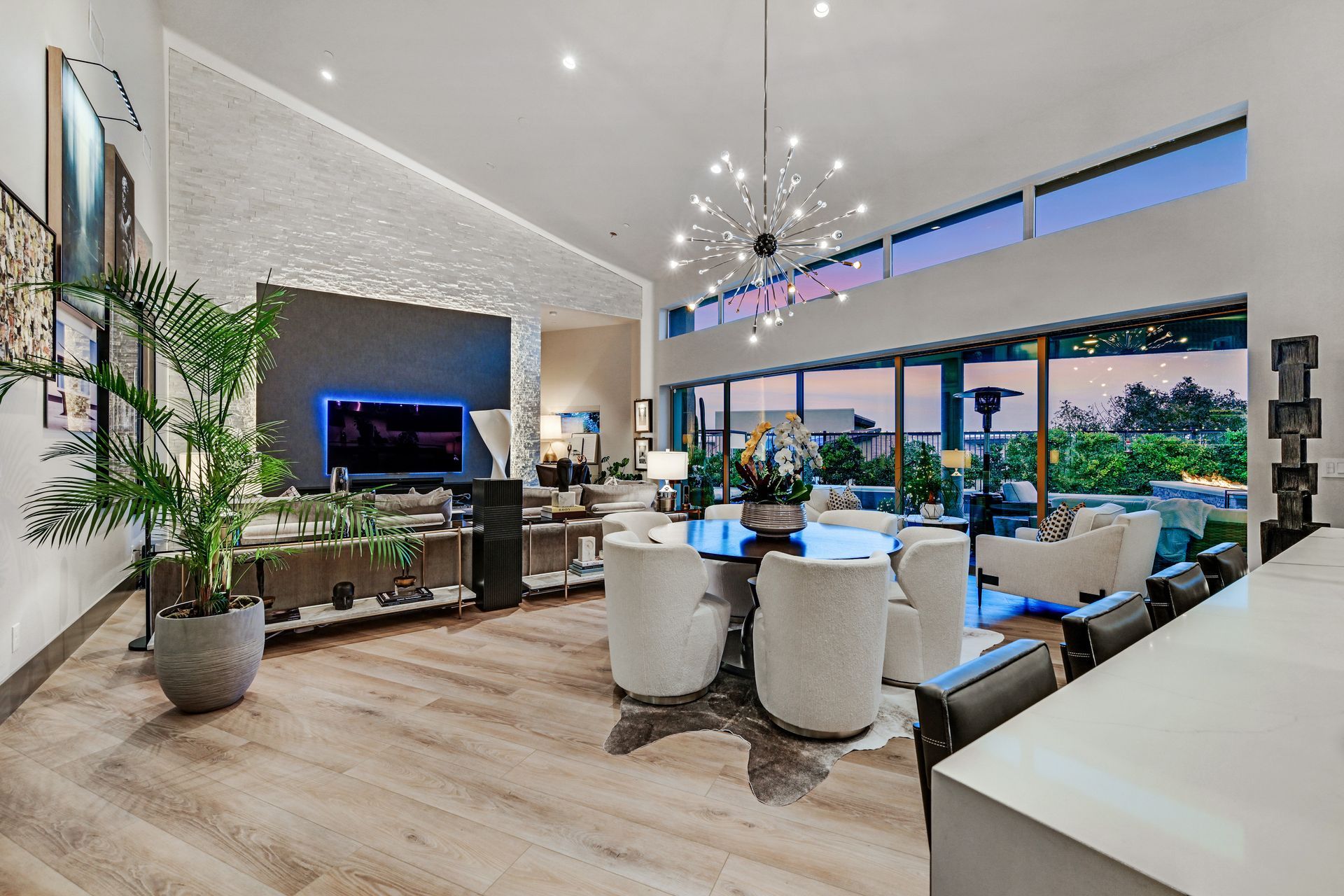 Spacious modern living room with high ceilings, large windows, and contemporary decor.