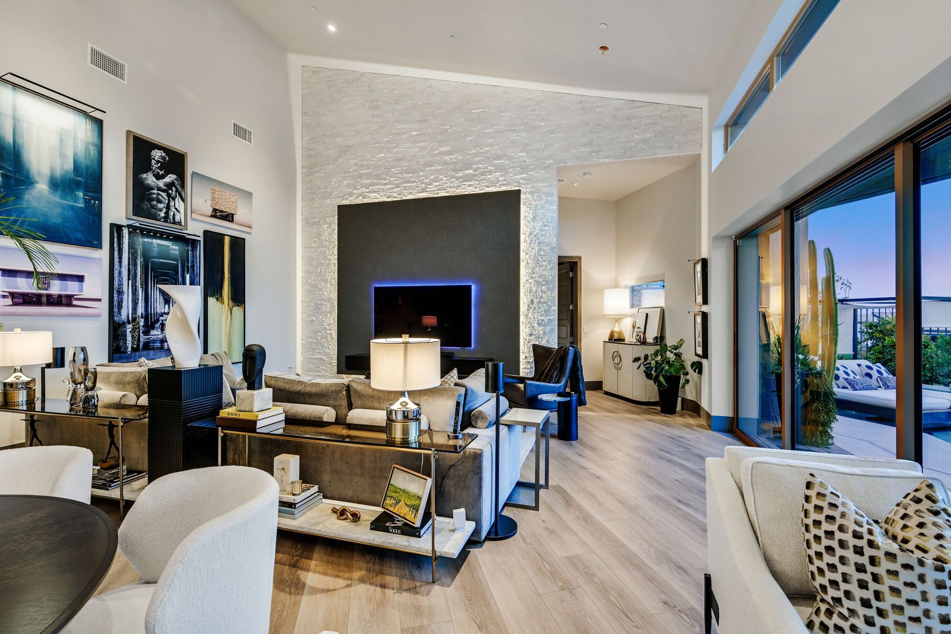 Spacious modern living room with neutral colors, art, and an outdoor patio.