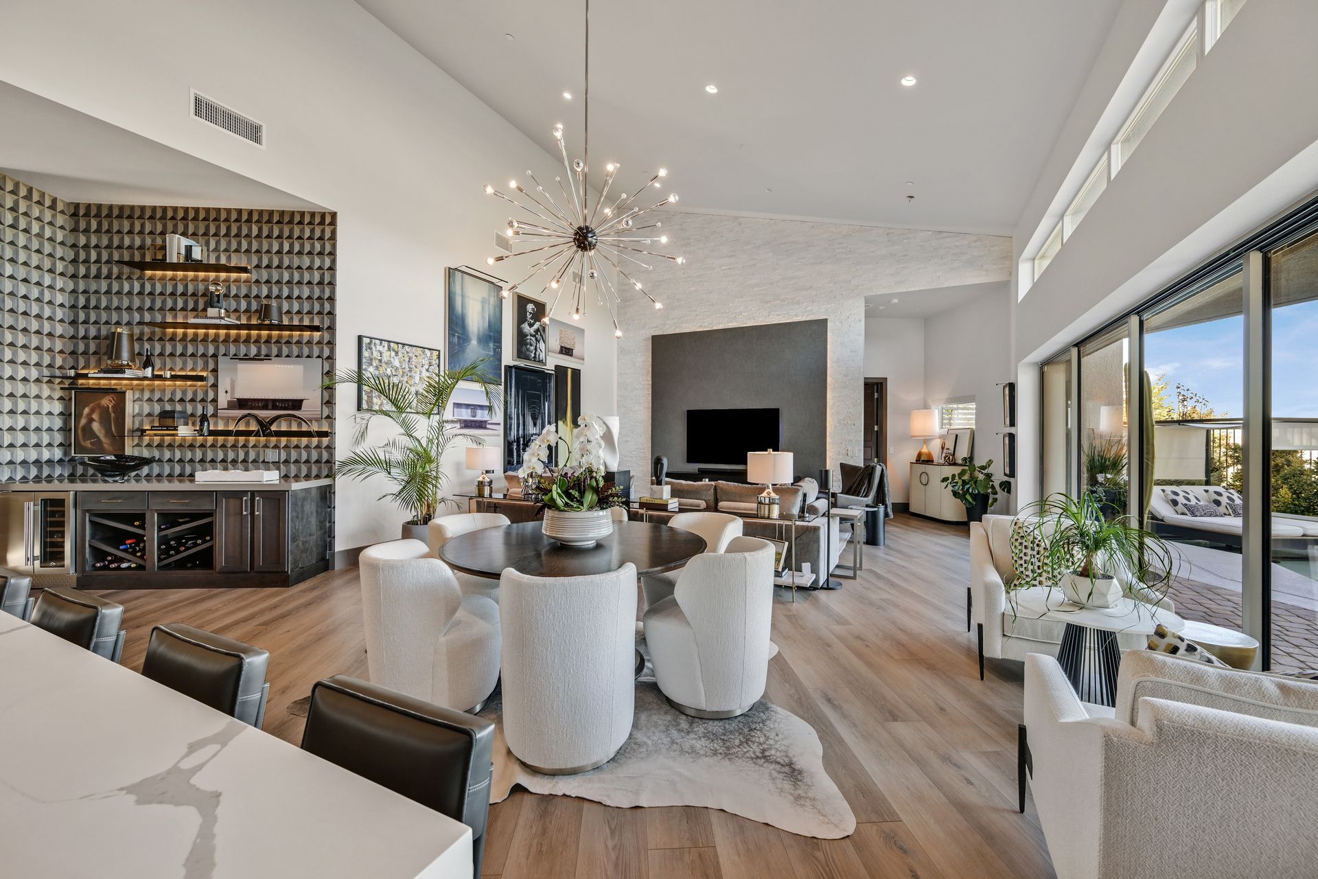 Spacious living room with high ceilings, light wood floors, and modern furniture.
