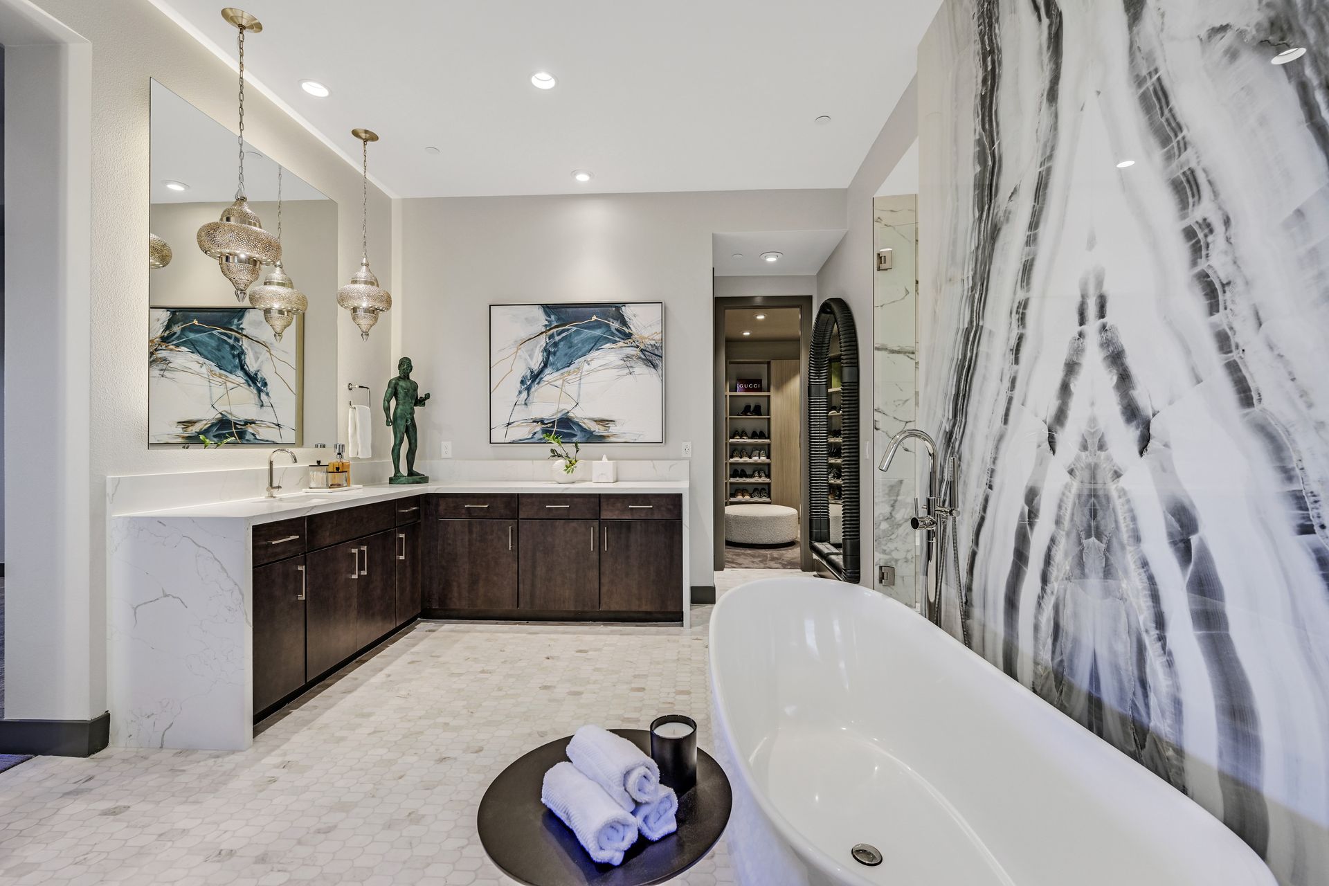 Modern bathroom with a freestanding tub, dark wood cabinets, and marble tile.