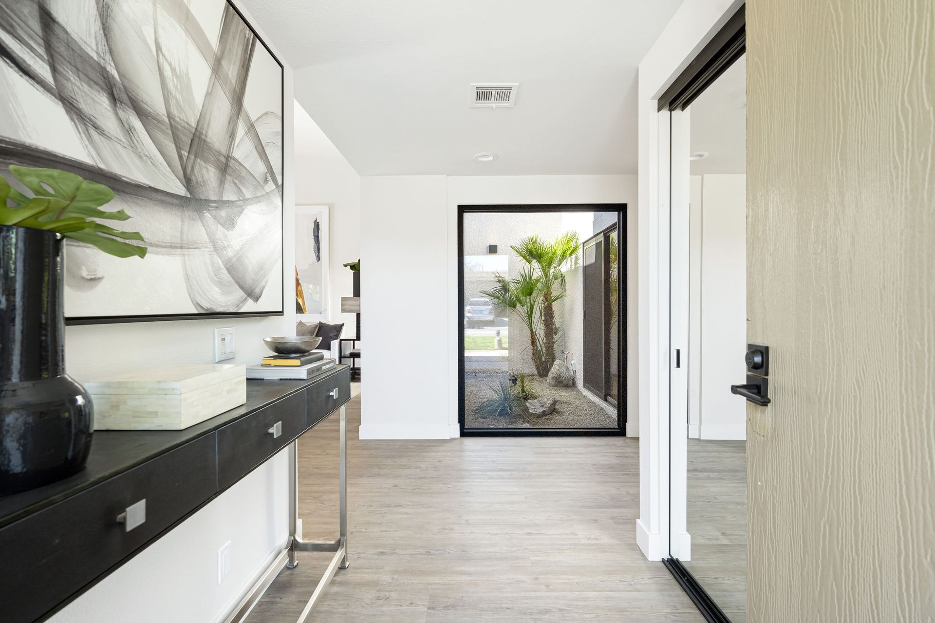 A hallway with a table and a door in a house.