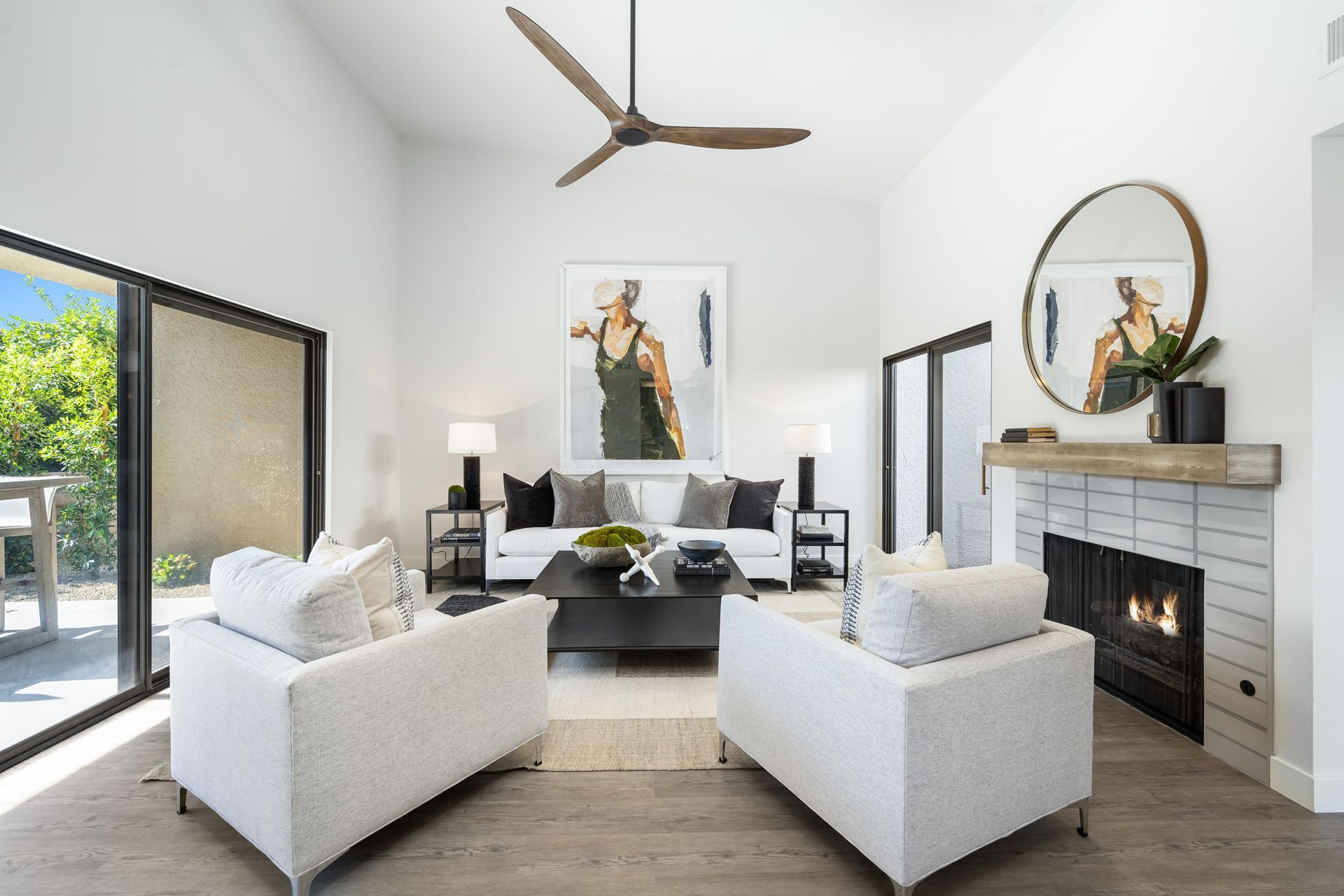 A living room with white furniture and a fireplace