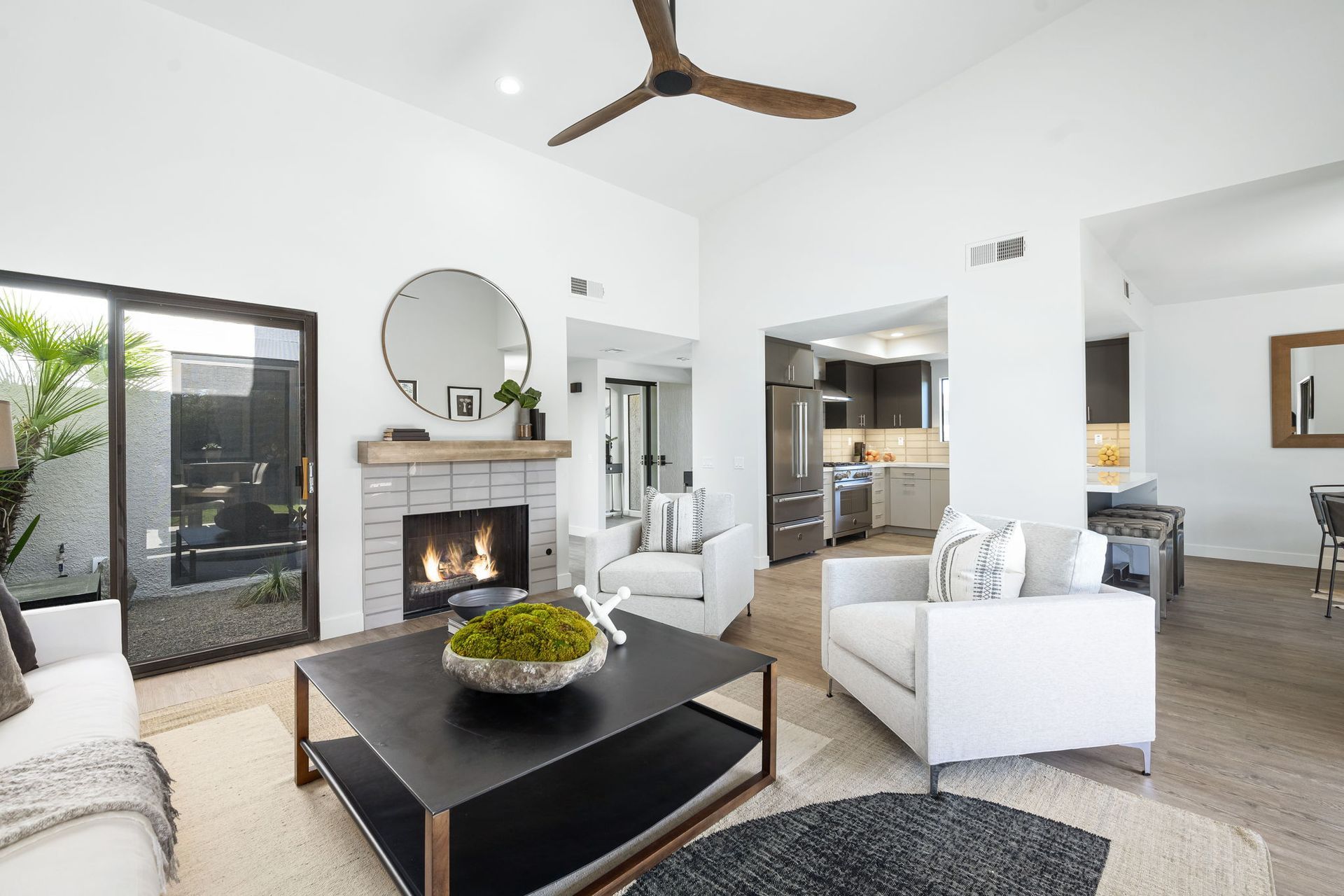 A living room filled with furniture and a fireplace with a ceiling fan.