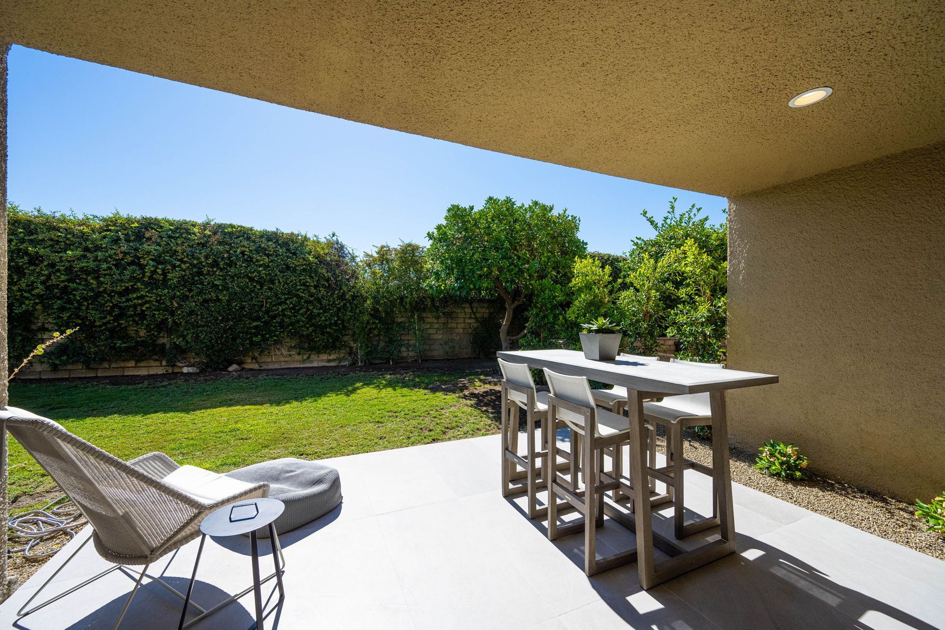 A patio with a table and chairs in the backyard