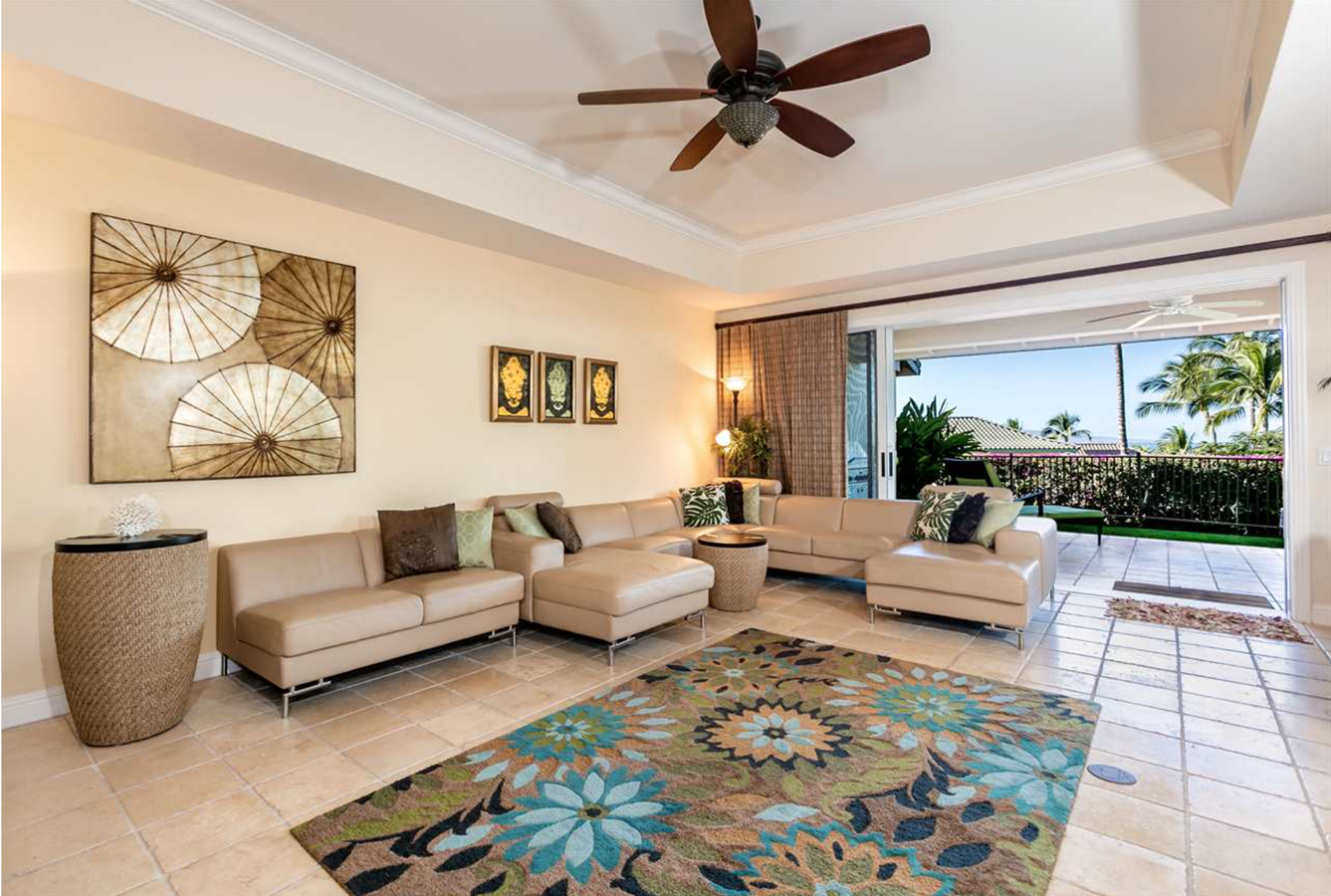 A living room filled with furniture and a ceiling fan.