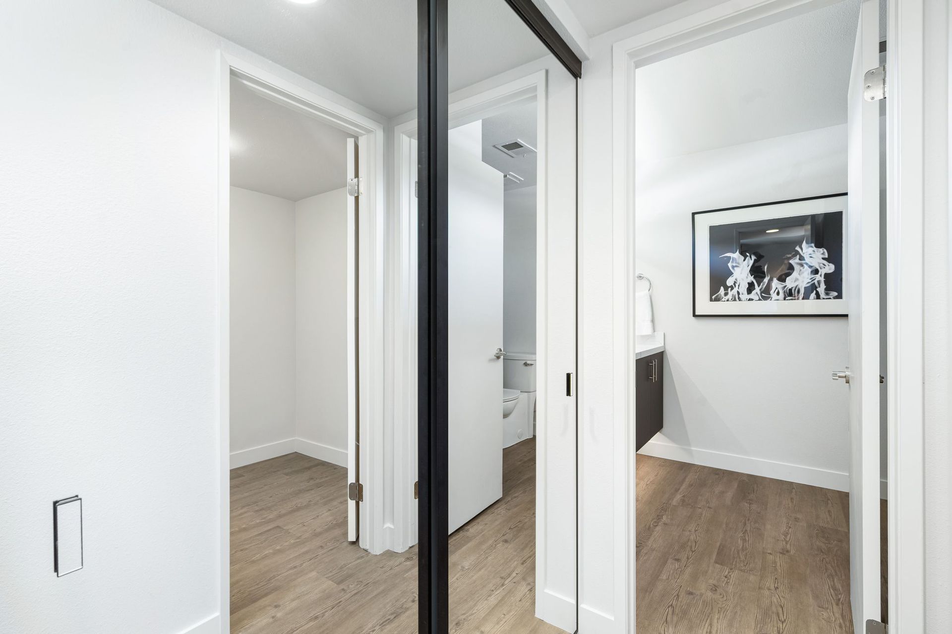 A hallway with a sliding glass door leading to a bathroom.